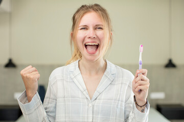 young pretty woman feeling shocked,laughing and celebrating success. toothwash concept