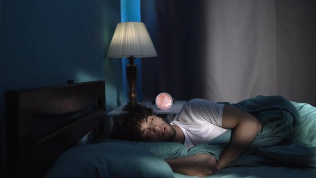 Young man sleeping in his cozy bed at night. Sleeping time concept