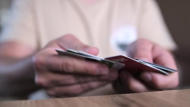 Close up, man hands go through pile cards of different banks. Financial services, payment methods, and the economy.