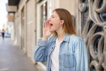 pretty young woman profile view, looking happy and excited, shouting and calling to copy space on the side