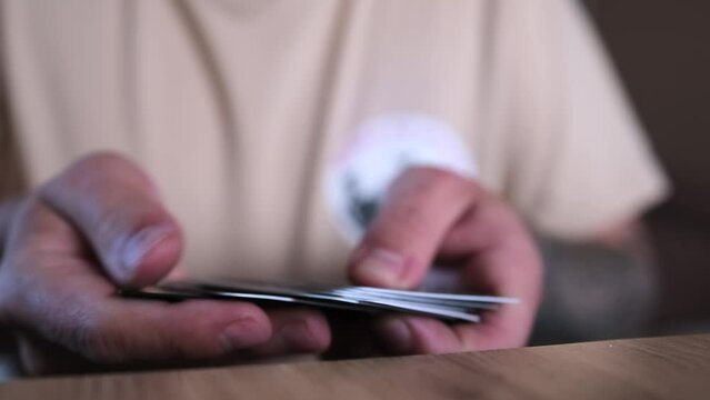 Man hands go through pile of bank cards and put them in stack, close up. Financial services, payment methods, and the economy.
