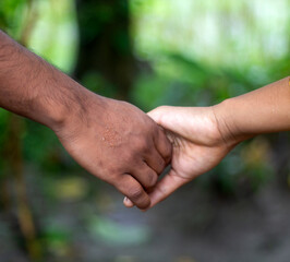 Two friends are hand-shaking, one with white hands and the other with black hands.
