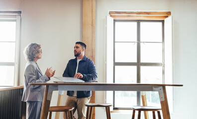 Two business professionals having a discussion in a coworking space