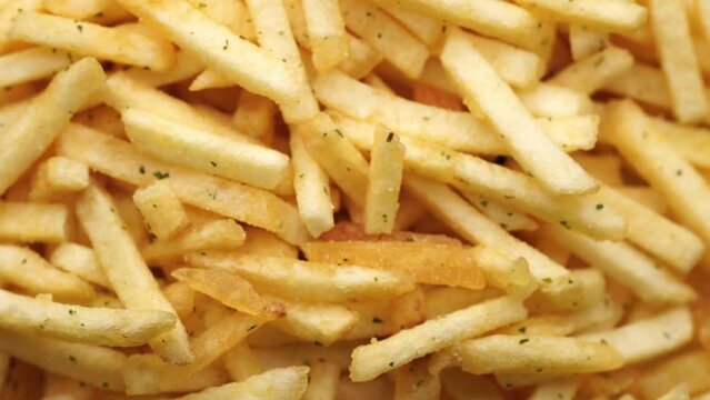 French fries background, closeup shot. Delicious potatoes with a golden fried crust. French fries background. Potato straw	
