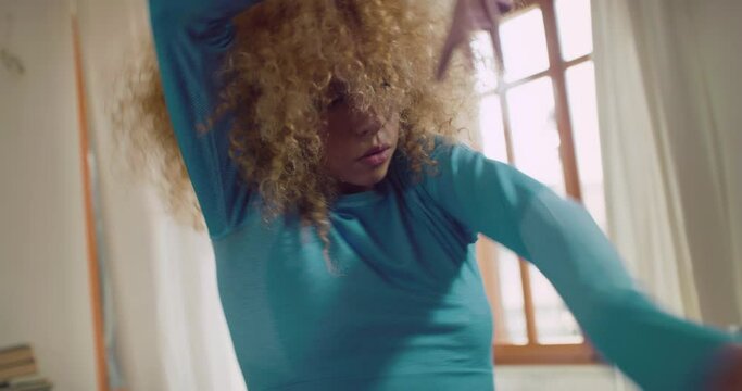 Close up Shot of Stylish Brazilian Girl with Afro Hair Practicing her Dancing Moves at Home on Sunny Day. Beautiful Professional Dancer Recording a Video of Choreography to Share on her Social Media 