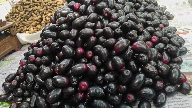 A pile of popular Indian Java plum fruits kept on a pushcart for sale