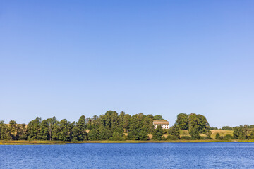 Fototapeta na wymiar Lake with a manor house on a hill