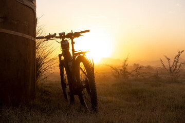 eBike (mountain bike) leaning against a reservoir at a windmill during sunset. Vanrhynsdorp Western Cape. South Africa.