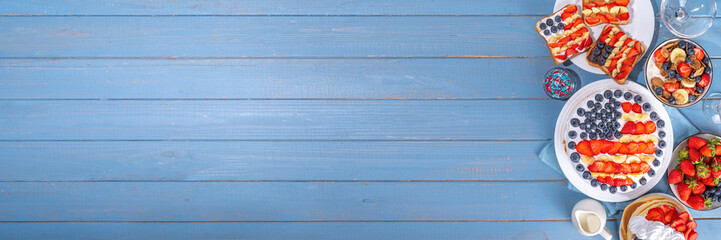 Fourth of July, Patriotic Independence day desserts.  4th of July sweet brunch food and snacks - toast sandwiches, flakes with berries, cake, pancakes, champagne with glasses, holiday decor, flags 