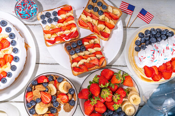 Fourth of July, Patriotic Independence day desserts.  4th of July sweet brunch food and snacks - toast sandwiches, flakes with berries, cake, pancakes, champagne with glasses, holiday decor, flags 