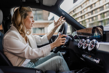 Upset woman driving her car in a city.