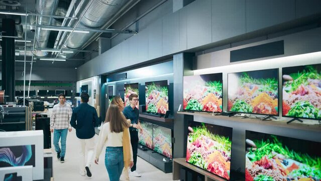 Beautiful Client Engaging in Dialogue with Retail Electronics Shop Consultant. Multiethnic Female Seeks Smart, Internet-Connected TV. Customer Exploring Television Choices in Modern Retail Store