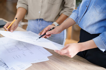 Engineering construction concept, Two female engineers checking blueprint of condominium together - 612384794
