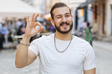 Okay. Happy cheerful young man looking approvingly at camera showing ok gesture, positive like...
