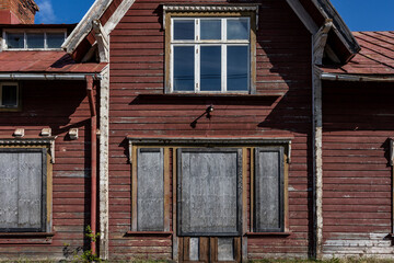 Fototapeta na wymiar Astrask, Sweden An old and abandoned boarded up railroad station in the Swedish woods and tracks.