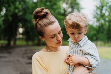 Young mother with little son on together walk after work day.