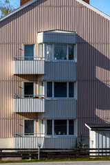 Sorsel, Sweden A small apartment building facade with balconies in the sun with shadows.