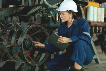 Female engineer or worker in safety clothes working in industrial factory. Industry, maintenance, production of parts in factories.