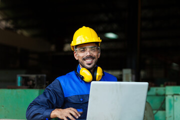 Fototapeta premium Handsome professional workers wearing safety vests and hard hats. Looking into the distance in a large factory Background with machines, warehouses, industrial plants. Image of a personal engineer. co