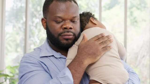 Loving African American dad embracing baby and baby girl sleeping on stepfather shoulder. Happy family with pleasure spending time at home, Being a father and Fatherhood family love relationship
