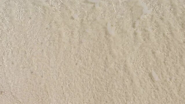 The incoming wave washes away the inscription 2023 in the sand.The end of the old and the beginning of the new year.The concept of the outgoing 2023.The numbers are written in the sand.Beach holidays