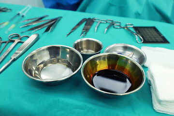 
saline and disinfectant In a stainless steel container On the table covered with green cloth, operating room