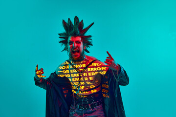 Rock and roll. Young man, rock musician, punk with neon filter reflection on body, posing on blue...