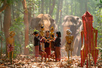 Group of Asian children enjoy to practice manipulate the puppets in  front of big elephant in...