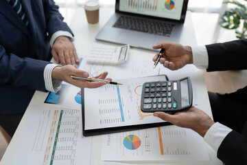 team work process Business team use calculator to calculate figures, business statistics, profit, cost analysis, growth rate graph document. data charts on the desk