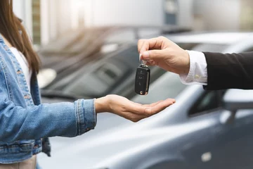 Fotobehang transportation rental automotive business concept. Close up hands of rental auto agent giving car remote key to client to travel sightseeing. © Pormezz