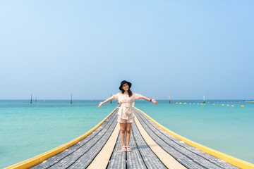 Young asian woman standing on pontoon walkway in tropical sea