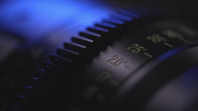 camera lens close-up of the dial with blue light in the background and blurred lens background, anamorphic lens, macro photography, video art