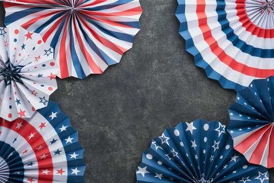 4th of July background. USA paper fans, Red, blue, white stars, balloons, gold confetti on gray dark concrete background. Happy Labor, Independence or Presidents Day. American flag colors. Top view.