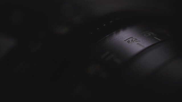 camera lens close-up of the dial with blue light in the background and blurred lens background, anamorphic lens, macro photography, video art