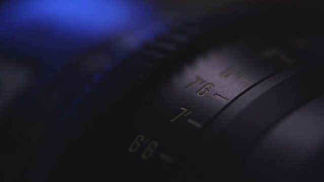 camera lens close-up of the dial with blue light in the background and blurred lens background, anamorphic lens, macro photography, video art