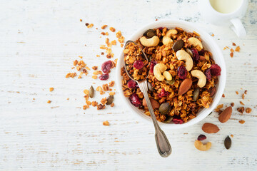 Homemade granola in glass jar with greek yogurt or milk and cashews, almonds, pumpkin with dried...