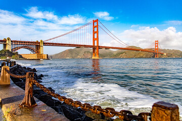 Golden Gate Bridge of San Francisco in the state of California, USA under a blue sky and ocean. Seen from the viewpoint of the Californian city's waterfront. American bridge concept.