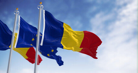 Romania and European Union flags waving in the wind on a clear day