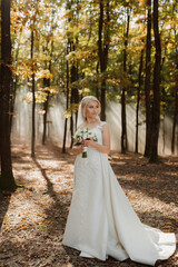 the bride is walking against the background of a fairy-tale fog in the forest. The rays of the sun break through the smoke, a fairy-tale wedding