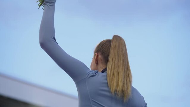 Young Female Athlete Celebrates a Win on a podium, receives a gold medal