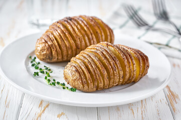 Traditional Swedish recipe delicious baked potatoes with herbs and oil, Hasselback potato.