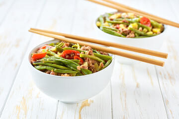 Fried pork with green beans ginger hot peppers and spices on a wooden table. Asian cuisine.