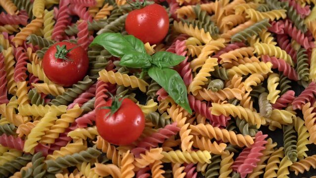 Ravvicinato di pomodori e basilico con pasta da cuocere