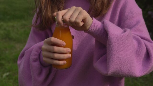 Girl opens a bottle of juice