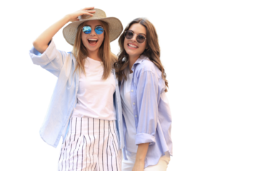 Two young smiling hipster women in summer clothes posing on a transparent background. Female showing positive face emotions.