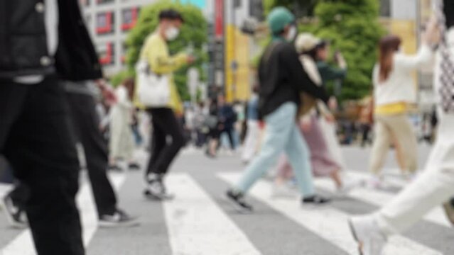 【社会】人々が歩いて移動する東京の昼の渋谷スクランブル交差点　ぼかし　スローモーション