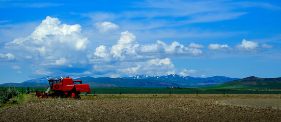 Fototapeta premium Old Red Farm Equipment in Country Farm Field