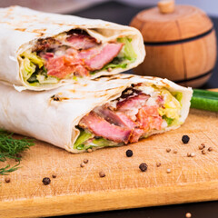 Delicious kebab with meat, lettuce, tomato, onion and sauce with french fries.
