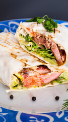 Delicious kebab with meat, lettuce, tomato, onion and sauce with french fries.