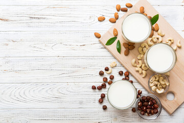 Obraz na płótnie Canvas Set or collection of various vegan milk almond, cashew, on table background. Vegan plant based milk and ingredients, top view